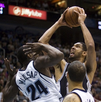 Tim Duncan avança sobre a marcação de Paul Millsap (AP Photo/Douglas C. Pizac)